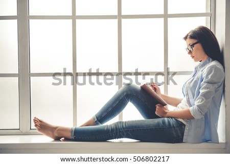 Stockfoto: Young Confident Teacher Or Office Manager Making Notes By Desk