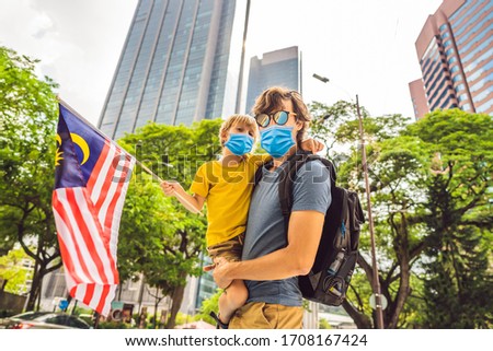 Stockfoto: Dad And Son Tourists In Malaysia With The Flag Of Malaysia Near The Skyscrapers Traveling With Kids