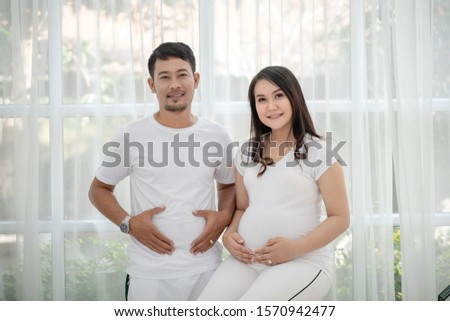 Stock photo: A Pregnant Young Woman And Her Husband A Happy Family Standing At The Red Autumn Hedge Future Fath