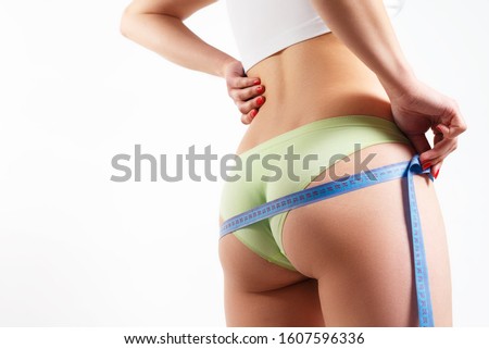 Foto stock: Young Beautiful Woman Measuring Her Leg Isolated On The White Background