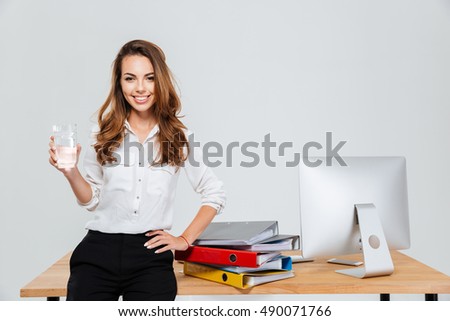 Stock fotó: Charming Woman Holding A Glass Of Water While Standing Against A White Background