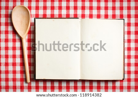 Stockfoto: Wooden Spoon And Book On A Wooden Board With A Checkered Tablecloth