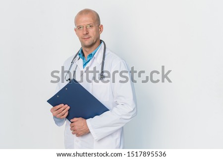 Foto stock: Young Successful Bald Practitioner In Whitecoat Holding Document