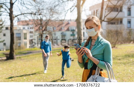 ストックフォト: People During Covid 19 Crisis Looking For News On Their Phones