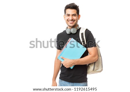 Сток-фото: Portrait Of A Male Student With A Backpack Holding Books Against White Background