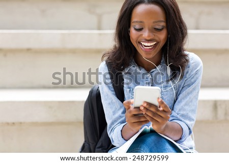 Stockfoto: Young African Girl Student With Backpack Listening Music Through Earphones