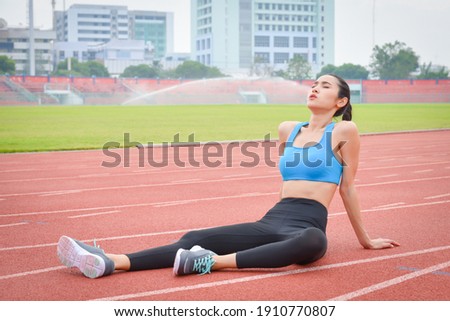 Foto d'archivio: Full Length Portrait Of An Exhausted Young Sportswoman In Earphones