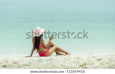 ストックフォト: Woman In Swimwear Using Mobile Phone Listening Music With Headphones