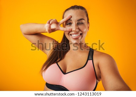 Foto d'archivio: Portrait Of Overweight Woman In Sportive Bra Using Cell Phone Fo