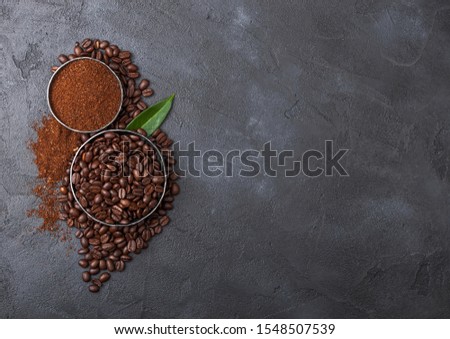 Foto d'archivio: Fresh Raw Organic Coffee Beans With Ground Powder And Cane Sugar Cubes With Coffee Trea Leaf On Blac