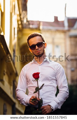 Stockfoto: Beautiful Young Brunette With Red Roses Modern Building Behind