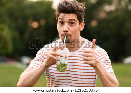 Сток-фото: Image Of Young Man 20s Walking Through Park And Drinking Bevera