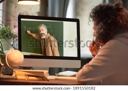 Foto stock: Rear View Of A Caucasian Teacher Teaching Something To A Mixed Race School Boy On A Whiteboard With