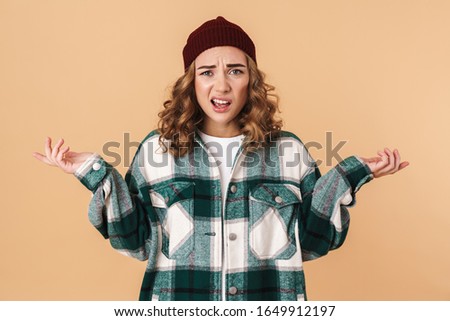 Foto stock: Photo Of Nice Confused Woman In Knit Hat Posing With Throwing Up Hands