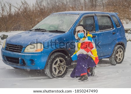 Zdjęcia stock: Winter Accident On The Road A Man Changes A Wheel During A Snowfall Winter Problems