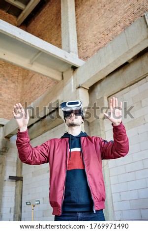 Happy Boy Looking Through Virtual Reality Simulator While Sitting On Chair Against Grey Vignette Stockfoto © Pressmaster