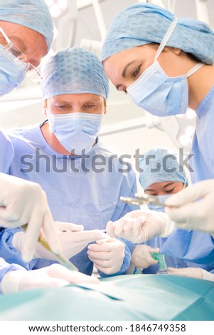 Foto stock: Careful Surgeons With Patient In Operating Room