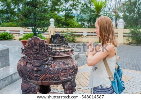 Сток-фото: Young Woman Traveler Praying In Polite Action With Incense Sticks At Buddhism Temple In Vietnam