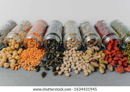 Foto stock: Image Of Nutrient Pinenuts Mung Beans Sunflower Seeds Chickpea Pistachio Spilled From Glass Cont