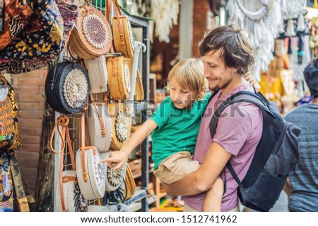 Foto d'archivio: Dad And Son At A Market In Ubud Bali Typical Souvenir Shop Selling Souvenirs And Handicrafts Of Ba