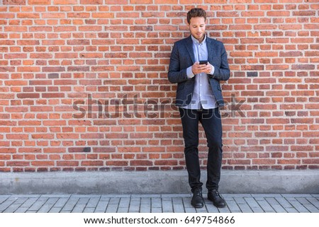 Сток-фото: Businessman Sms Texting Phone App In City Street On Brick Wall Background Business Man Holding Smar