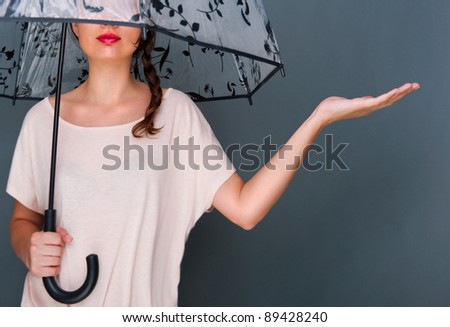 Stock photo: Young Fashionable Woman Holding Umbrella Standing Against Grey B