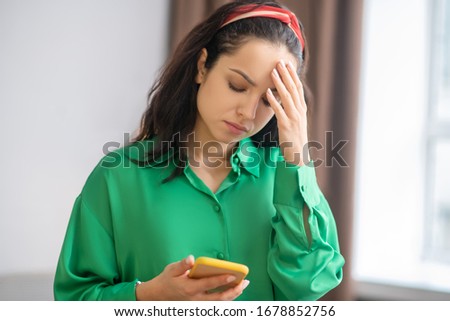 Stockfoto: Concentrated Woman Holding Hand Near Forehead And Looking Far Away