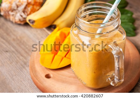 Stock photo: Freshly Blended Yellow Mango Fruit Smoothie In Glass Jars With Straw Mint Leaves Mango Slices Cop