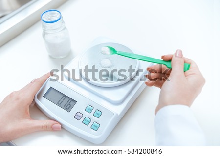 Foto stock: Close Up Partial View Of Chemist Weighing Reagent On Laboratory Scales
