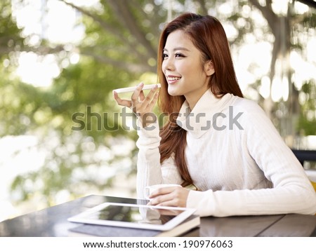 Stock foto: Happy Young Woman Recording Voice Message In Urban Environment