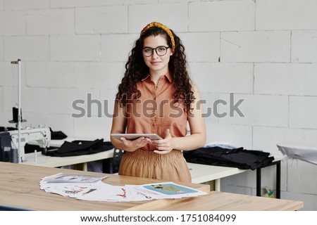 Young Confident Fashion Designer With Tablet Scrolling Through Online Ideas Сток-фото © Pressmaster