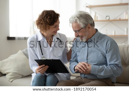 Stock photo: Young Female Clinician In Medical Uniform And Eyeglasses Standing In Isolation