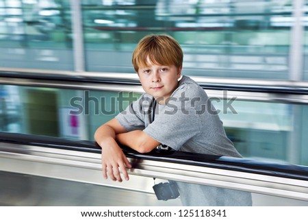 Foto d'archivio: Boy In The Departure Hall In The New Airport On A Moving Stairc