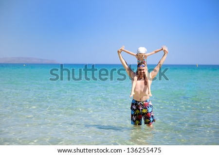 Stock photo: Happy Family With Little Girl Standing Knee Deep In Sea On Beach