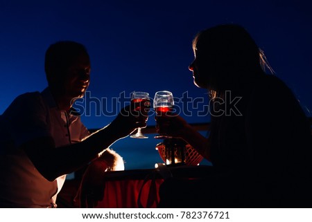 [[stock_photo]]: Ilhouettes · féminines · et · masculines · sur · le · coucher · du · soleil · derrière · la · table · boire · de · G