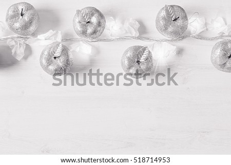 Stockfoto: Christmas Silver Apples Decoration And Lights Burning On A White Wooden Background