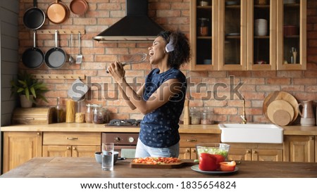 Stok fotoğraf: Crazy Real Woman Housewife On Kitchen Eating Perfoming Bizare