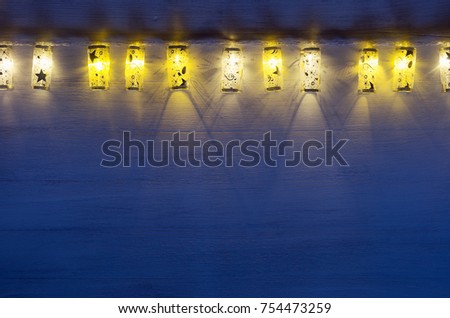 Stockfoto: Christmas Lights Lanterns Burn On Blue Ultramarine Wooden Background New Year Festive Home Interior