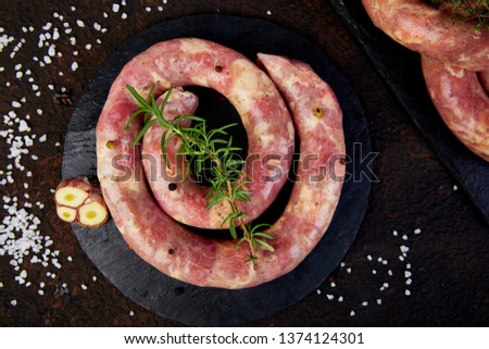 Foto stock: Raw Spiral Pork Sausages With Rosemary Salt And Peper On Wooden Cutting Board