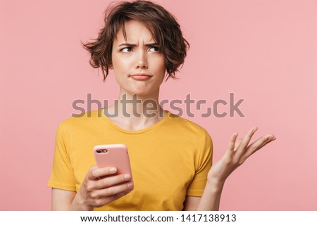 Foto stock: Confused Young Woman Posing Isolated Over Pink Background Holding Rainbow Umbrella