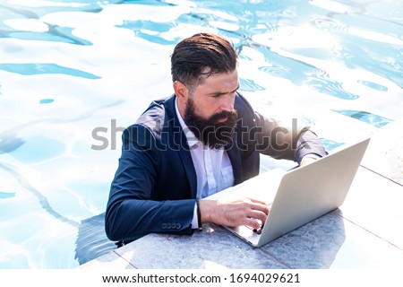 [[stock_photo]]: Young Freelancer Working On Vacation Next To The Swimming Pool