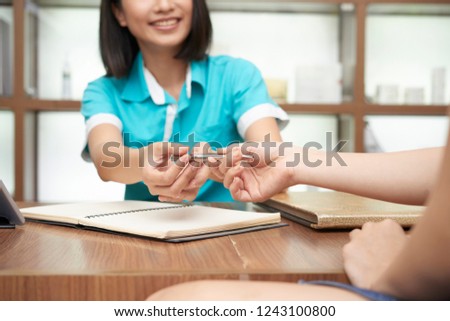 Foto d'archivio: Crop Receptionist Giving Pen To Guest