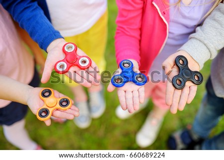 Foto d'archivio: Boy Playing With Fidget Spinner Child Spinning Spinner On The Playground Blurred Background