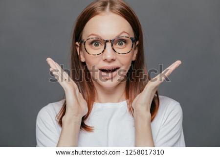 Stok fotoğraf: Wow Thats Great Surprised Pleased Beautiful Woman Has Pleasant Appearance Spreads Palms Near Face