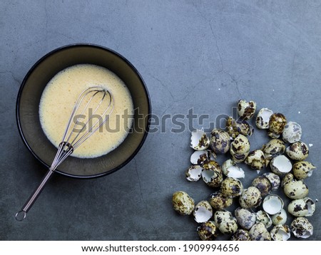 Foto d'archivio: Quail Eggs On A Black Textured Background Raw Broken Egg With The Yolk Easter Card Side View