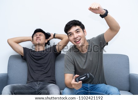 Stock fotó: Happy Asian Gamer Boy Winning While Playing Video Games On Compu