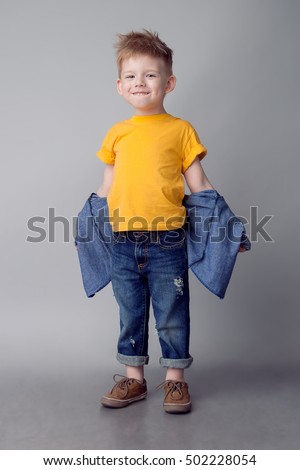 Stockfoto: Portrait Of Cute Little Blonde Caucasian Boy In Yellow T Shirt Scared With Hands Near His Face On Gr