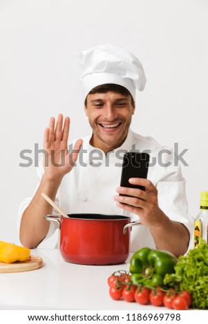 Foto stock: Chef Man Isolated Over White Wall Background Cooking Using Laptop Computer
