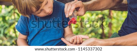 [[stock_photo]]: Father And Son Using Wash Hand Sanitizer Gel In The Park Before A Snack