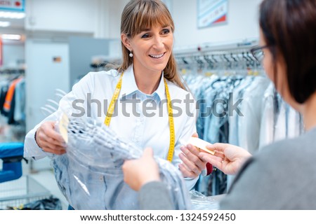 Stock photo: Woman Customer Getting Clean Clothes Back From The Textile Cleaning